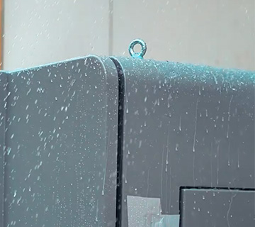 Waterproof Sealing Test for EV Charger Housing Automatic spray equipment testing waterproof and sealing performance of an EV charger housing in the factory workshop.