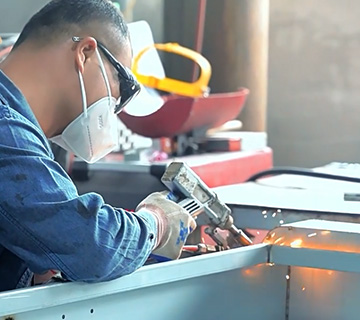 Welding Process for EV Charger Housing in Factory Workshop Technician welding parts of an EV charger housing in a factory workshop, showing the charging station manufacturing process.