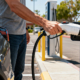 Electric vehicle owner holding charging cable at Level 2 station