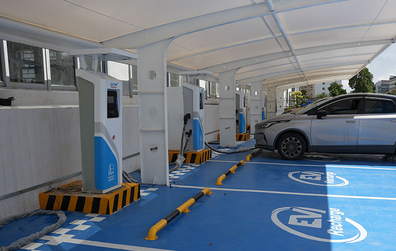 Commercial Level 3 DC fast charging station powering an electric vehicle in a parking lot