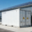 An industrial solar battery storage solution featuring a 20ft containerized BESS installed next to a factory warehouse.