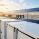 Large-scale solar plus battery storage solution for manufacturing plants in Poland, featuring containerized BESS cabinets and rooftop solar.