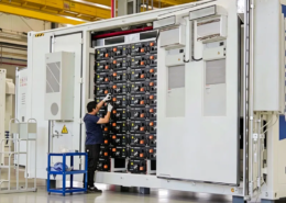 engineers inspecting 5MWh liquid-cooled BESS container in factory, battery energy storage system testing and quality assurance before deployment