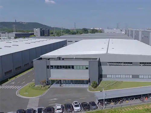 Aerial view of battery energy storage system manufacturing facility with multiple production workshops for large-scale BESS production