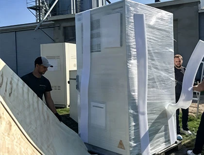 workers unpacking battery energy storage container at project installation site
