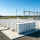 A utility-scale grid connected battery storage installation featuring containerized LFP racks and a high-voltage substation.