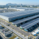 Premium C&I solar installations on a logistics warehouse rooftop featuring a solar carport for electric fleets.