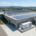 A complete turnkey battery energy storage system for sale installed next to a modern manufacturing facility.