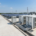 An integrated 20ft BESS container installed on a site foundation pad alongside solar PV panels for optimal commercial energy storage.