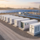 Turnkey industrial containerized BESS for solar farms co-located with utility-scale PV arrays under a morning sky.