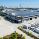 An optimized commercial battery storage sizing installation integrated with rooftop solar PV panels for an industrial factory.