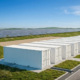 High-voltage grid scale battery storage system container array working beside a utility substation