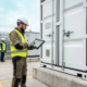 Engineer verifying battery passport and serial data at a stationary BESS container