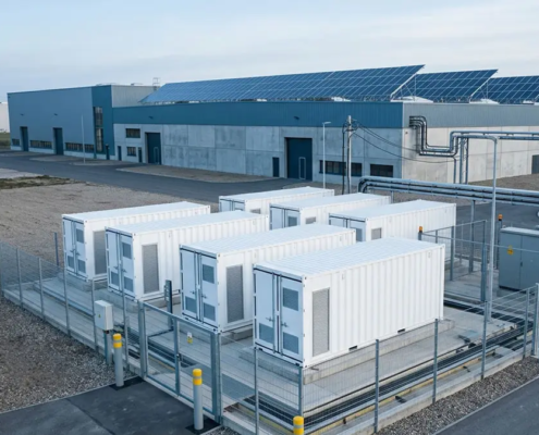 AC-coupled battery storage beside a European factory with rooftop solar PV